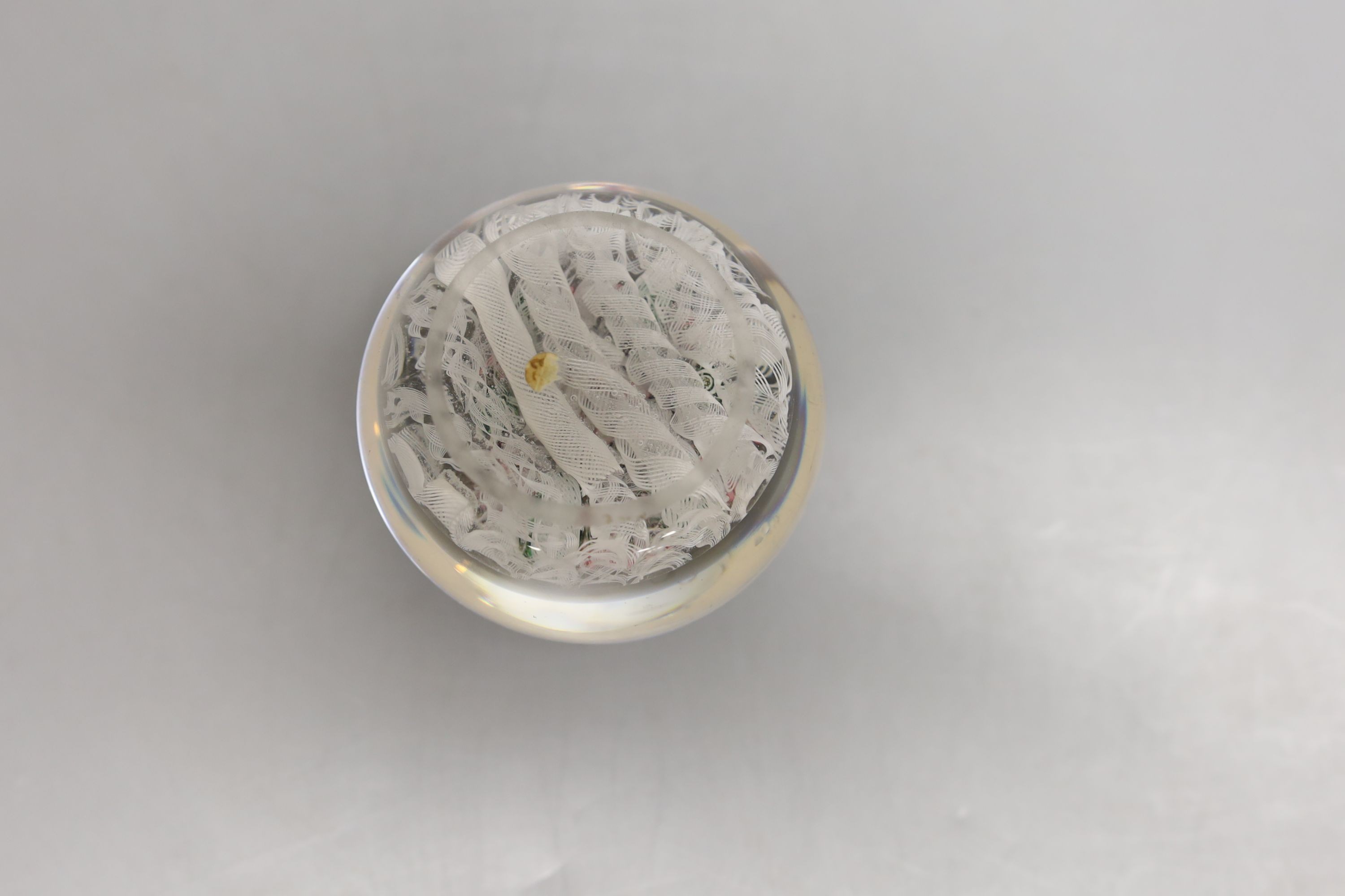 A mid 19th century French concentric millefiori glass paperweight, with scrambled latticino ground